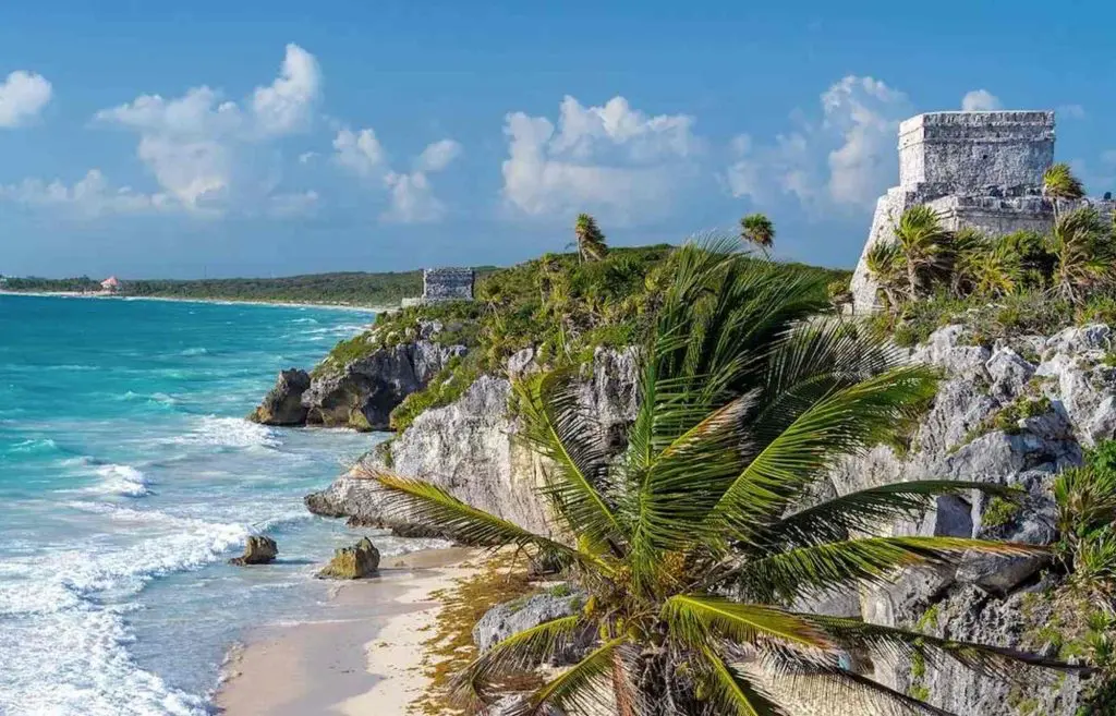 Tulum ruins perched on a cliff overlooking the Caribbean Sea, a top day trip from Cancun